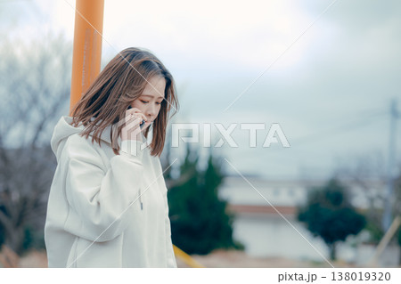 屋外で通話する20代女性の横顔ポートレート 138019320
