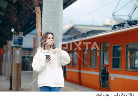 駅のホームでスマホを操作する女性 138019488