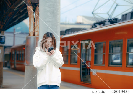 駅のホームでスマホを操作する女性 駅のホームでスマホを操作する女性 138019489