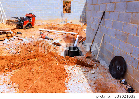 Workers are digging preparing ground for plumbing at construction site with tools machines present. 138021035