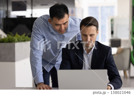 Project coordinator reviewing lapto p screen with subordinate at office workplace Project coordinator reviewing lapto p screen with subordinate at office workplace 138021046