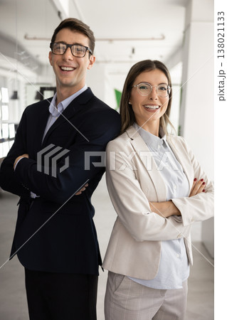 Male, female team members posing confidently in office Male, female team members posing confidently in office 138021133