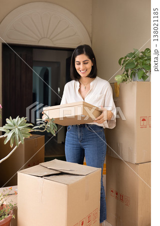 Happy young Hispanic homeowner woman moving into new house Happy young Hispanic homeowner woman moving into new house 138021185