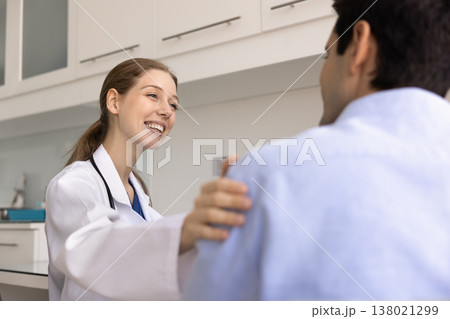 Positive woman nurse or doctor talks warmly with male patient Positive woman nurse or doctor talks warmly with male patient 138021299