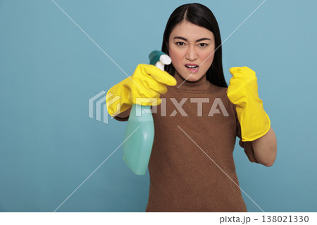 Angry frustrated asian young housewife in rubber gloves and detergent spray standing in a fight pose, Cleaning home concept, Aggressive energetic housekeeper feeling negative 138021330