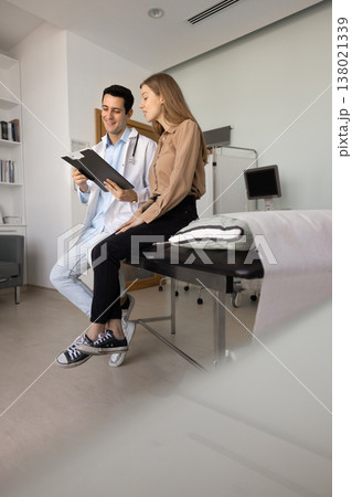 Doctor and woman patient reviewing medical chart 138021339
