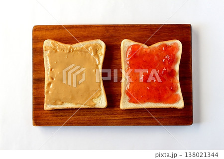 真上から見た白背景の食パンに塗ったピーナッツバターといちごジャム 138021344