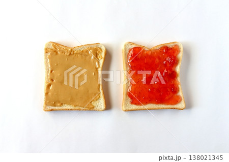 真上から見た白背景の食パンに塗ったピーナッツバターといちごジャム 真上から見た白背景の食パンに塗ったピーナッツバターといちごジャム 138021345