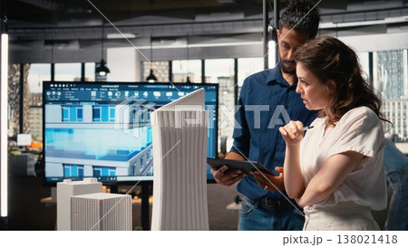 Diverse real estate team creating the layout for a residential area, simulating site preparation with 3D models before the project approval. Modern infrastructure city planning. Diverse real estate team creating the layout for a residential area, simulating site preparation with 3D models before the project approval. Modern infrastructure city planning. 138021418