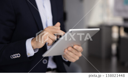 Closeup businessman in formal suit using digital tablet in office 138021448