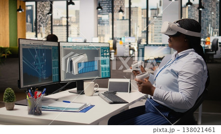 Technician using VR headset to create solar powered device design using alternative energy technology. Worker uses virtual reality simulation to develop eco friendly solar gadgets prototypes, camera A 138021461