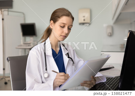 Doctor making notes while holds patient anamnesis or files Doctor making notes while holds patient anamnesis or files 138021477