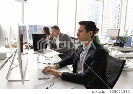 Latin executive handling multiple tasks in modern open space office Latin executive handling multiple tasks in modern open space office 138021536
