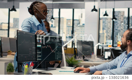 Portfolio manager in wheelchair and coworkers analyze stock market to enhance investment returns. Man with disability and colleagues in inclusive office identify investment opportunities 138021636