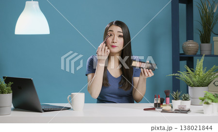 POV of influencer filming makeup tutorial with eyeshadow palette, using cosmetics on camera. Female beauty vlogger recording video to do product review and give tips. Tripod shot. POV of influencer filming makeup tutorial with eyeshadow palette, using cosmetics on camera. Female beauty vlogger recording video to do product review and give tips. Tripod shot. 138021844