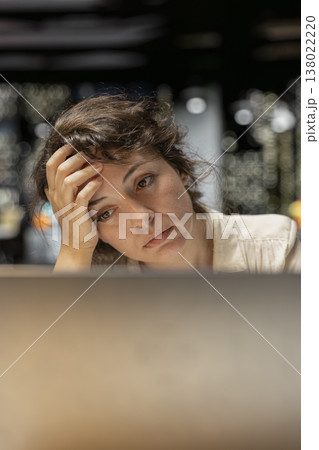 Discouraged woman creating plans and documenting objectives to share with executives during the next morning meeting. Employee drained in a mental haze doing overtime, pushing limits. Discouraged woman creating plans and documenting objectives to share with executives during the next morning meeting. Employee drained in a mental haze doing overtime, pushing limits. 138022220