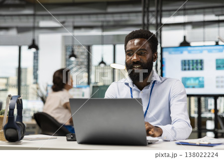 African American team leader working in modern office, researching budget and preparing project plans. Black male manager seated at desk with laptop for business analytics and data research. African American team leader working in modern office, researching budget and preparing project plans. Black male manager seated at desk with laptop for business analytics and data research. 138022224