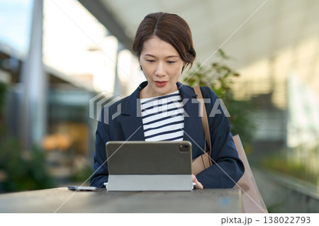 屋外でタブレットを使って仕事をする30代日本人ビジネスウーマン 屋外でタブレットを使って仕事をする30代日本人ビジネスウーマン 138022793