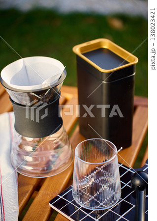 Specialty pour over coffee setup with dripper and glass outdoors 138023421