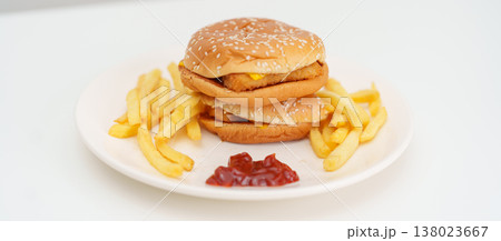 juicy beef burger with melted cheddar cheese, potato chips on table. Unhealthy, High calorie, Fast food craving, Obesity, diet, weight loss, junk food and lifestyle juicy beef burger with melted cheddar cheese, potato chips on table. Unhealthy, High calorie, Fast food craving, Obesity, diet, weight loss, junk food and lifestyle 138023667