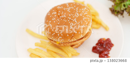 juicy beef burger with melted cheddar cheese, potato chips on table. Unhealthy, High calorie, Fast food craving, Obesity, diet, weight loss, junk food and lifestyle 138023668