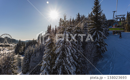 Snowy mountain view with ski lift and ferris wheel under blue sky 138023693