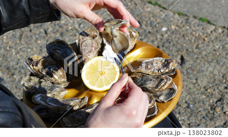 Close-up of a girl taking an oyster from a tray Close-up of a girl taking an oyster from a tray 138023802