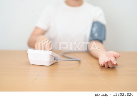 woman checking Blood pressure by Blood pressure monitor with Cuff. Systolic, SYS, Diastolic, DIA, Pulse, Hypertension, Hypotension, Heart rate, Cardiovascular Disease and May World hypertension day 138023820