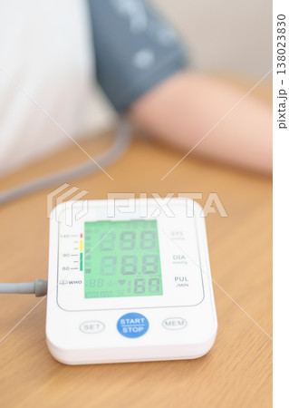 woman checking Blood pressure by Blood pressure monitor with Cuff. Systolic, SYS, Diastolic, DIA, Pulse, Hypertension, Hypotension, Heart rate, Cardiovascular Disease and May World hypertension day 138023830
