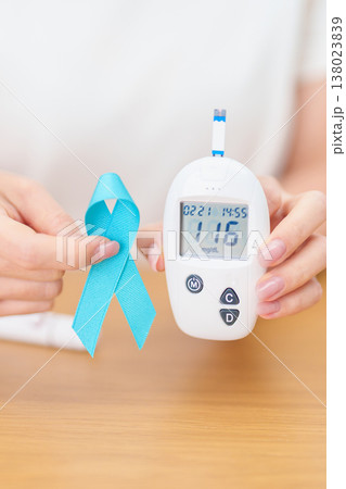 Hand show Blue Ribbon and digital blood glucose meter with lancet pen. high blood sugar level, November World Diabetes Day, Awareness month, Glycemia,, Hyperglycemia and insulin testing and checking Hand show Blue Ribbon and digital blood glucose meter with lancet pen. high blood sugar level, November World Diabetes Day, Awareness month, Glycemia,, Hyperglycemia and insulin testing and checking 138023839