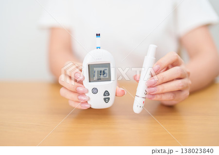 Hand checking Diabetes or Blood glucose self testing by digital blood glucose meter with lancet pen. high blood sugar level, World Diabetes Day, Glycemia, Hypoglycemia, Hyperglycemia and insulin Hand checking Diabetes or Blood glucose self testing by digital blood glucose meter with lancet pen. high blood sugar level, World Diabetes Day, Glycemia, Hypoglycemia, Hyperglycemia and insulin 138023840