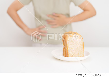 Gluten intolerance, Gluten free and celiac disease or Wheat allergy. woman with wheat bread and having abdominal pain after eat gluten. stomach ache, Nausea, Bloating, Gas, Diarrhea and Skin rash 138023856