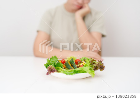 Unhappy woman disgust gesture and Bored to eat fresh organic vegetables. healthy nutrition, weight loss, clean eating, Healthy food eating, Vegan, Wellness, Green dieting and Healthy lifestyle 138023859