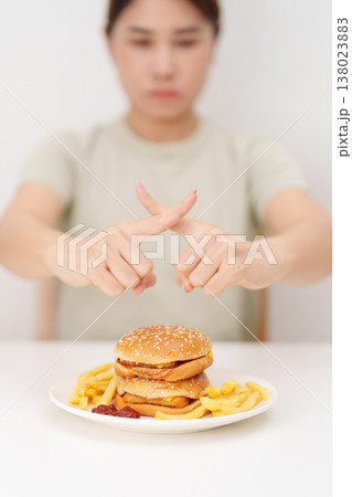 Unhappy woman showing Rejecting and refusing with Juicy beef burger, potato chips and carbonated Soft drinks. Unhealthy, High calorie, Fast food craving, Obesity, diet, weight loss and junk food Unhappy woman showing Rejecting and refusing with Juicy beef burger, potato chips and carbonated Soft drinks. Unhealthy, High calorie, Fast food craving, Obesity, diet, weight loss and junk food 138023883