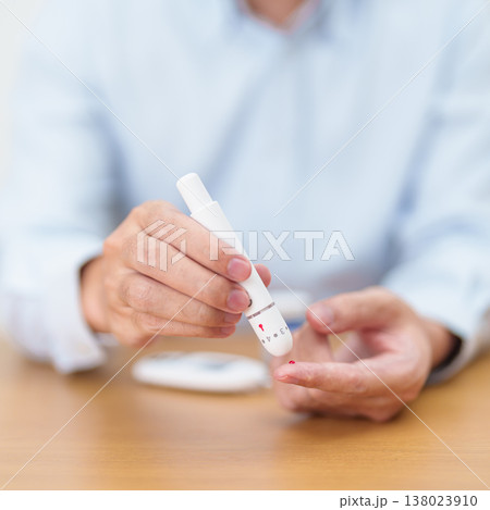 Hand using lancet pen on finger with Blood drop glucose testing or Diabetes checking by digital blood glucose meter. blood sugar level, Diabetes Day, Glycemia, Hypoglycemia, Hyperglycemia and insulin Hand using lancet pen on finger with Blood drop glucose testing or Diabetes checking by digital blood glucose meter. blood sugar level, Diabetes Day, Glycemia, Hypoglycemia, Hyperglycemia and insulin 138023910