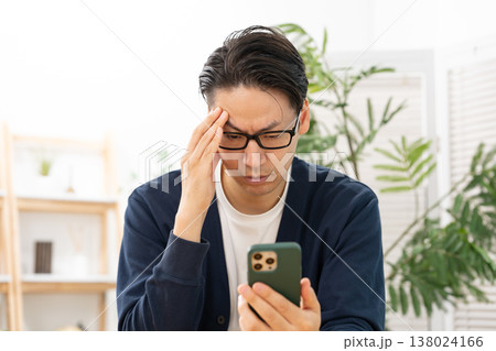 スマホを見て悩む男性　ショック 138024166