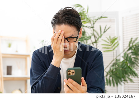 スマホを見て悩む男性　ショック 138024167