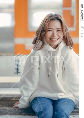 駅のベンチに座る20代女性のポートレート 138024180
