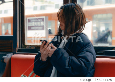 電車内でスマホを操作する20代女性のポートレート 電車内でスマホを操作する20代女性のポートレート 138024420