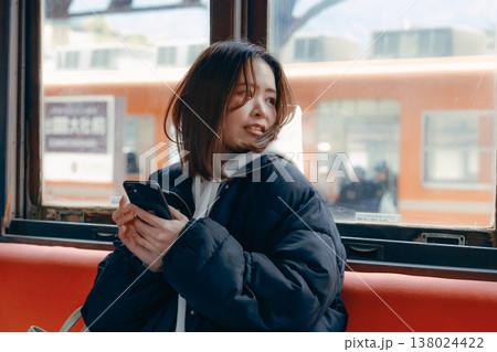 電車内でスマホを操作する20代女性のポートレート 電車内でスマホを操作する20代女性のポートレート 138024422