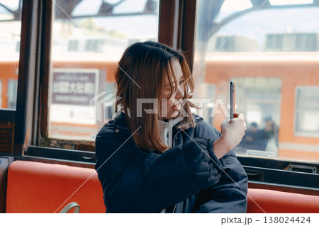 電車内でスマホを操作する20代女性のポートレート 138024424