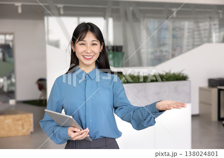 Happy Asian business professional showing air copy space on hand 138024801