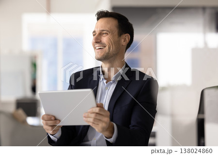 Hispanic office worker enjoying good news holding tablet in office Hispanic office worker enjoying good news holding tablet in office 138024860