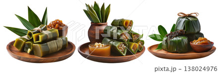 Filipino rice cakes wrapped in banana leaves with sugar sauce on wooden plate, Pandanus fruit paste, isolated on white background Filipino rice cakes wrapped in banana leaves with sugar sauce on wooden plate, Pandanus fruit paste, isolated on white background 138024976