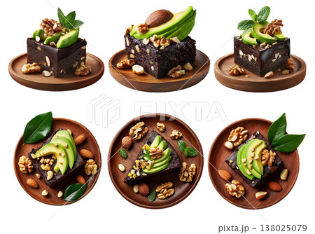 Rich chocolate brownie slice with avocado, walnuts, mint leaves and almond toppings on wooden round plate isolated on white Rich chocolate brownie slice with avocado, walnuts, mint leaves and almond toppings on wooden round plate isolated on white 138025079