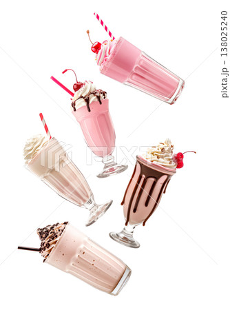 Multiple milkshakes with whipped cream shown isolated on white background, concept of sweet dessert treats 138025240