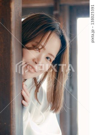 レトロ列車のドアから顔を出して微笑む20代女性 138025391