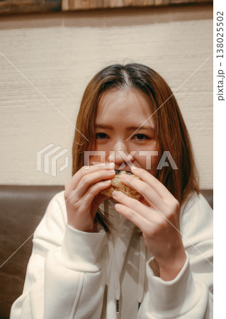 おにぎりを食べる笑顔の20代女性 138025502