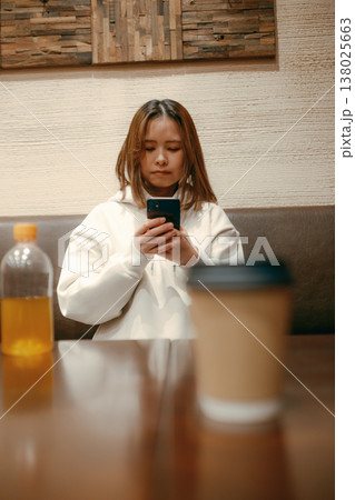 カフェでスマートフォン撮影をする20代女性 138025663