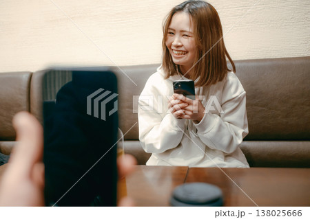 カフェでスマートフォン撮影をする20代女性 138025666